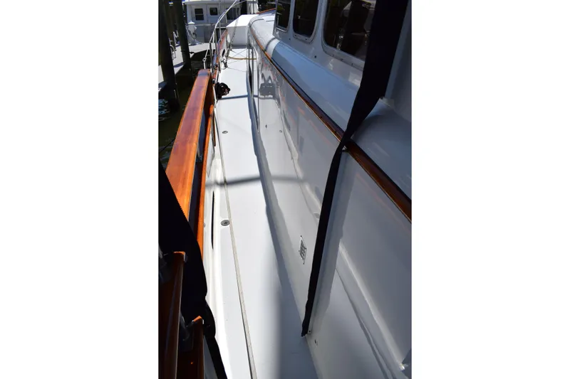 Slide: The Image of 1980 Cheoy Lee 52 Motorsailer deck with polished wood railing and white surface. - 17