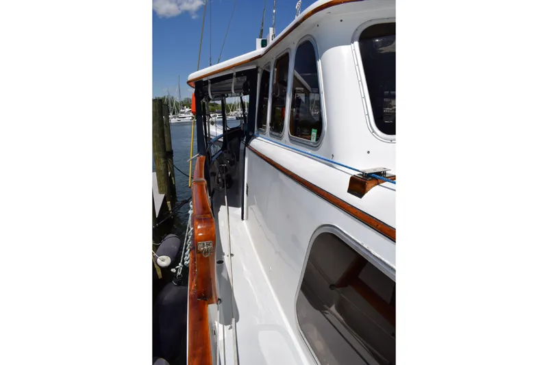 Slide: The Image of 1980 Cheoy Lee 52 Motorsailer with polished wood trim docked at marina. - 16