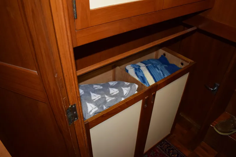 Slide: The Image of Wooden cabinet with blankets inside a 1980 Cheoy Lee 52 Motorsailer. - 65