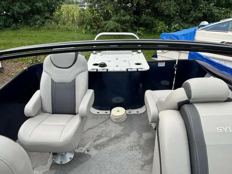 Slide: The Image of The image shows the cockpit of a 2021 Sylvan L3PF TRITOON with gray seating. - 2