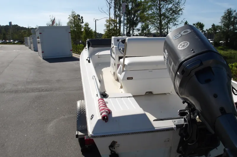 Slide: The Image of 2002 Wellcraft 160 Fisherman boat with outboard motor on trailer, parked outdoors. - 4
