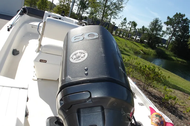Slide: The Image of 2002 Wellcraft 160 Fisherman boat with 60 HP engine, parked near a scenic pond. - 7