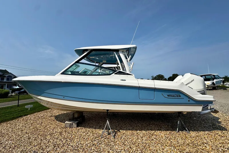 The Image of 2027 Boston Whaler 280 Vantage boat displayed on gravel, featuring sleek blue and white design. - 0