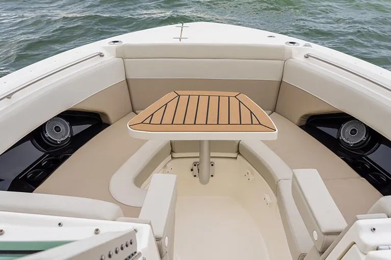 Slide: The Image of Manufacturer Provided Image: 2026 Boston Whaler 280 Vantage boat interior with seating and table on water. - 7