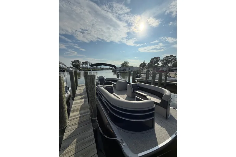 The Image of 2024 Harris Cruiser 230 pontoon boat docked under a sunny sky. - 3