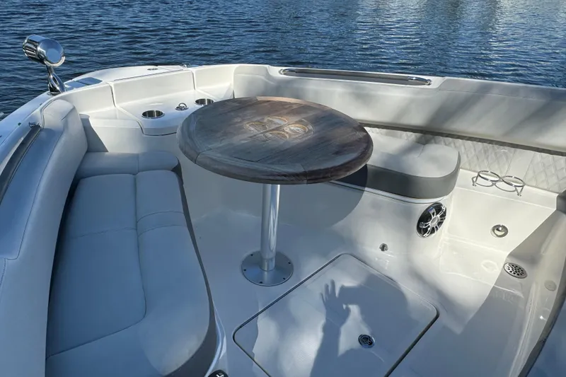 Slide: The Image of 2022 Sea Ray SLX 400 Outboard interior with seating and table on calm water. - 64