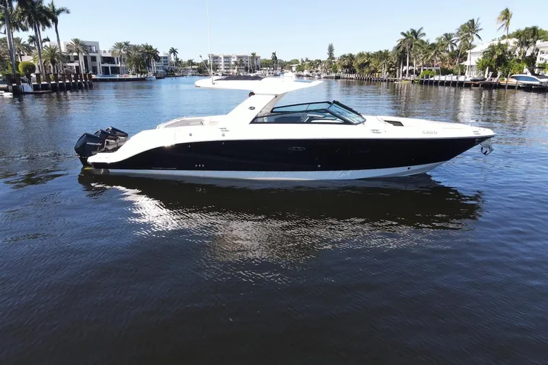 Slide: The Image of 2022 Sea Ray SLX 400 Outboard boat on a calm waterway, surrounded by palm trees. - 4