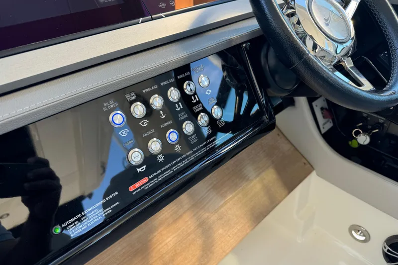 Slide: The Image of Control panel of 2022 Sea Ray SLX 400 Outboard with steering wheel and various buttons. - 59
