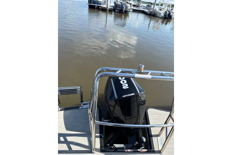 Slide: The Image of 2024 Harris Breeze 230 pontoon boat with Mercury outboard motor at dock. - 9