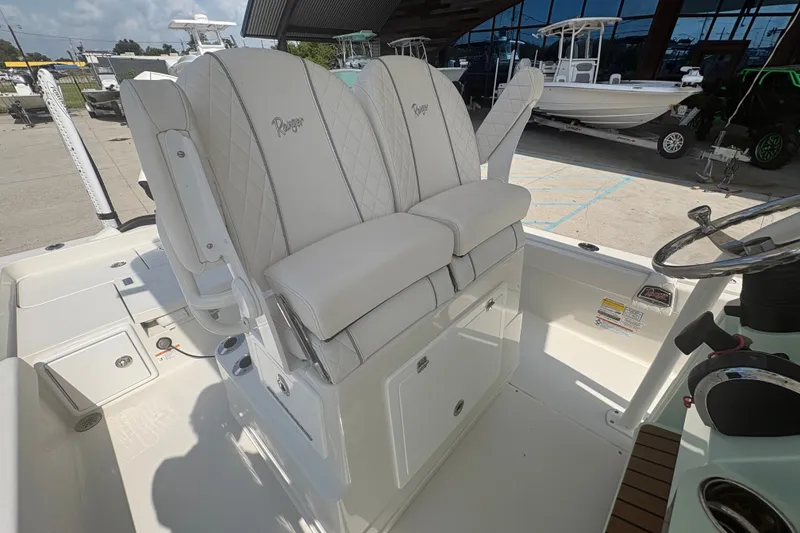 Slide: The Image of 2022 Ranger 2510 Bay boat interior with dual white cushioned seats and steering console. - 15