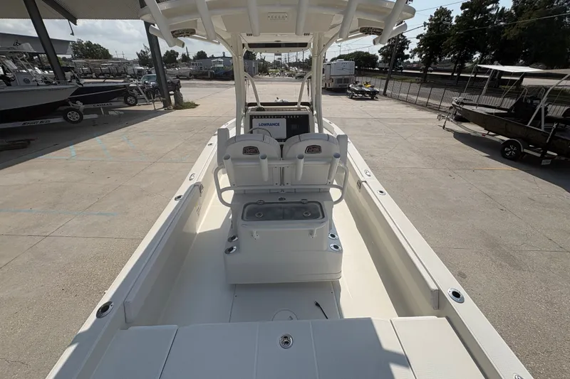 Slide: The Image of 2022 Ranger 2510 Bay boat interior with seating and console, parked outdoors. - 20