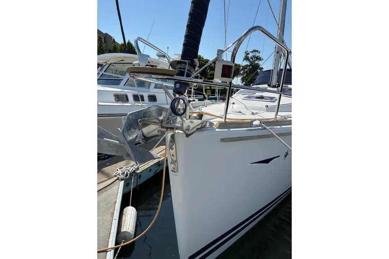 Slide: The Image of 2010 Jeanneau Sun Odyssey 42 DS sailboat docked, showcasing anchor and deck details. - 13