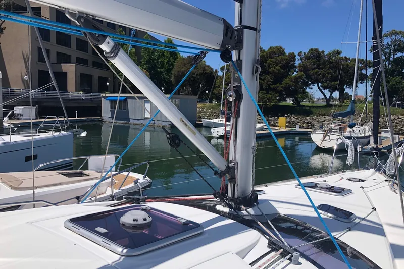 Slide: The Image of 2010 Jeanneau Sun Odyssey 42 DS sailboat docked in a marina, surrounded by other boats. - 24