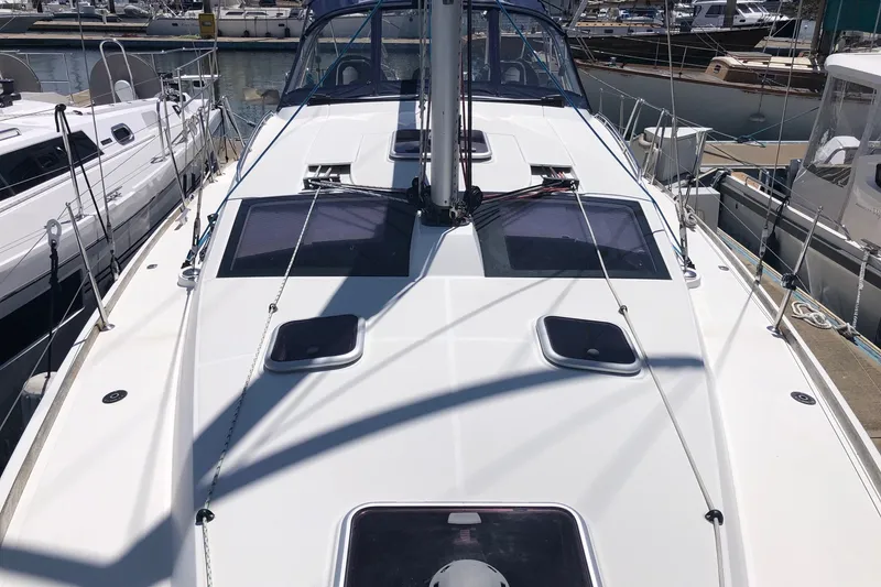 Slide: The Image of 2010 Jeanneau Sun Odyssey 42 DS sailboat docked at marina, showcasing sleek deck design. - 22