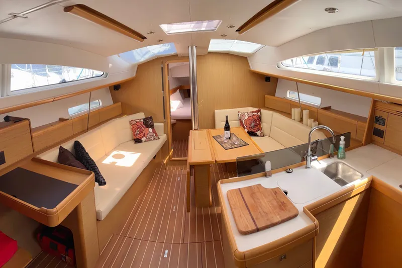 Slide: The Image of Interior of 2010 Jeanneau Sun Odyssey 42 DS yacht, featuring elegant seating and modern kitchen. - 1