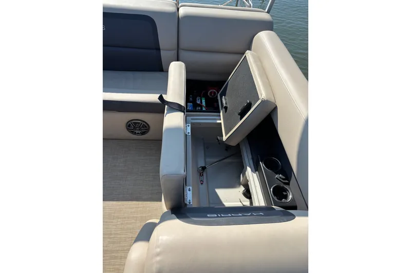 Slide: The Image of 2024 Harris Cruiser 230 boat interior with open storage compartment and cup holders. - 8