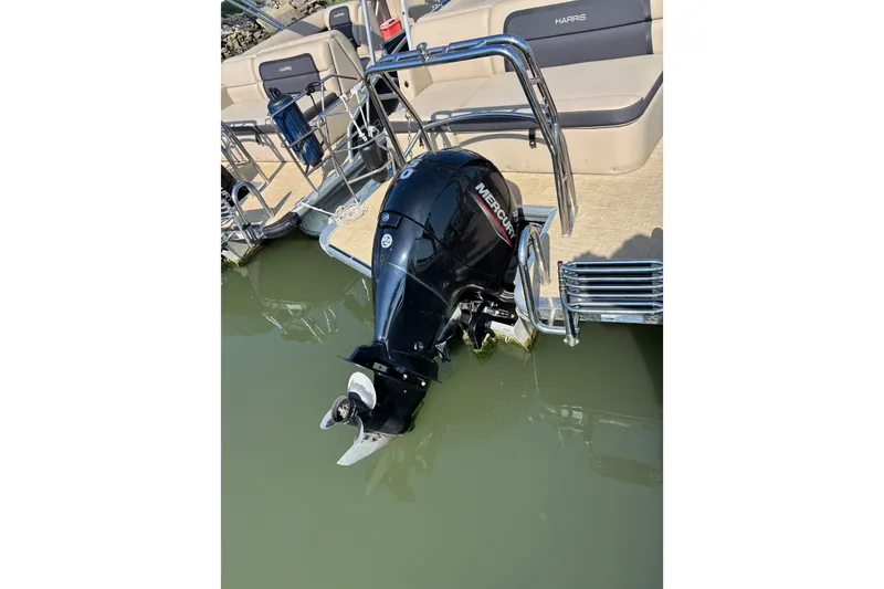 Slide: The Image of 2024 Harris Cruiser 230 pontoon boat with Mercury outboard motor in water. - 10