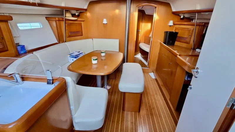Slide: The Image of 2006 Beneteau 393 yacht interior with wooden finish and cozy seating area. - 34