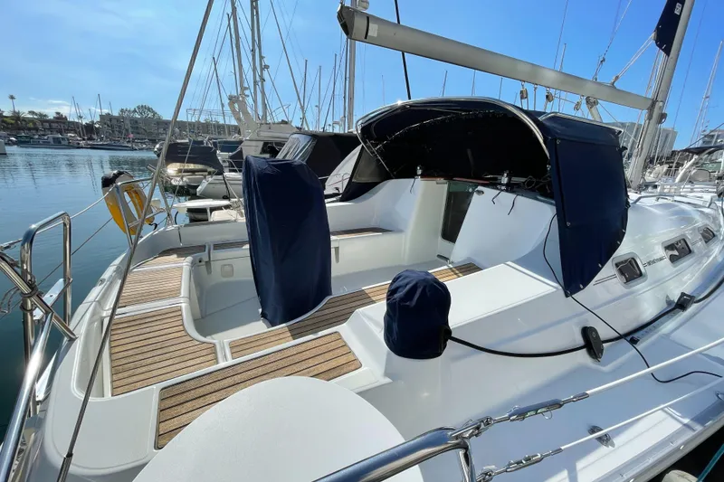 Slide: The Image of 2006 Beneteau 393 sailboat with covered cockpit, docked in a marina. - 15