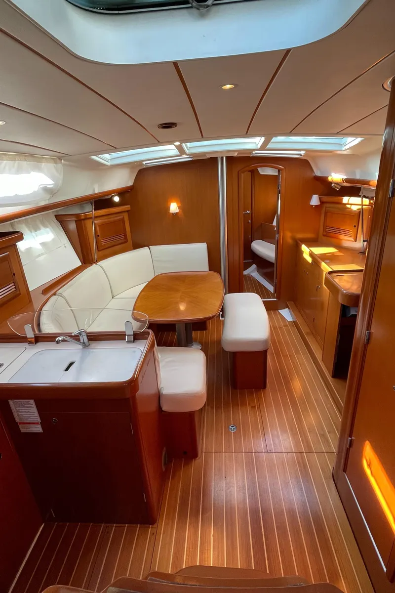 Slide: The Image of Interior of 2006 Beneteau 393 yacht with wood finish and cozy seating area. - 22