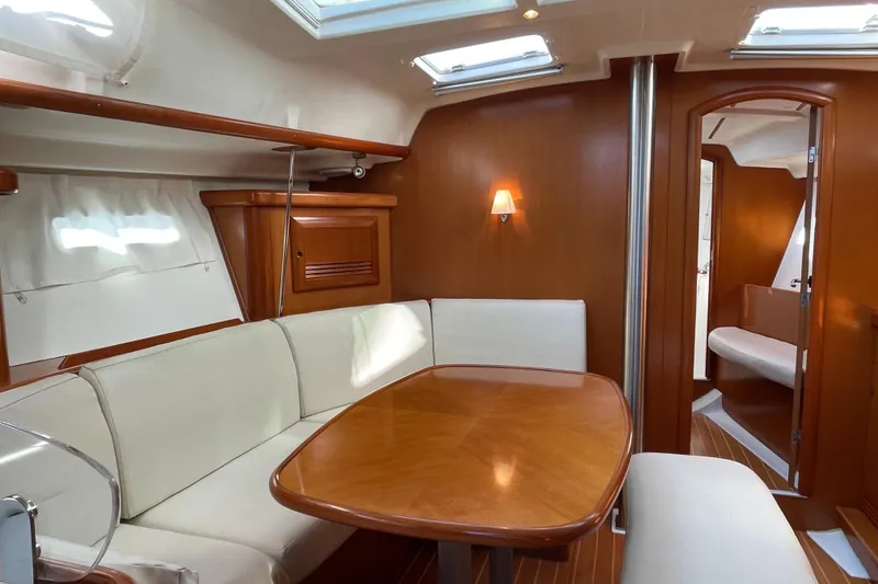 Slide: The Image of Interior of 2006 Beneteau 393 yacht with elegant wood finish and cozy seating area. - 26