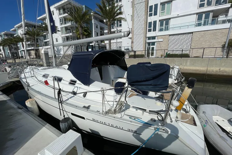 Slide: The Image of 2006 Beneteau 393 sailboat docked near modern waterfront buildings. - 23