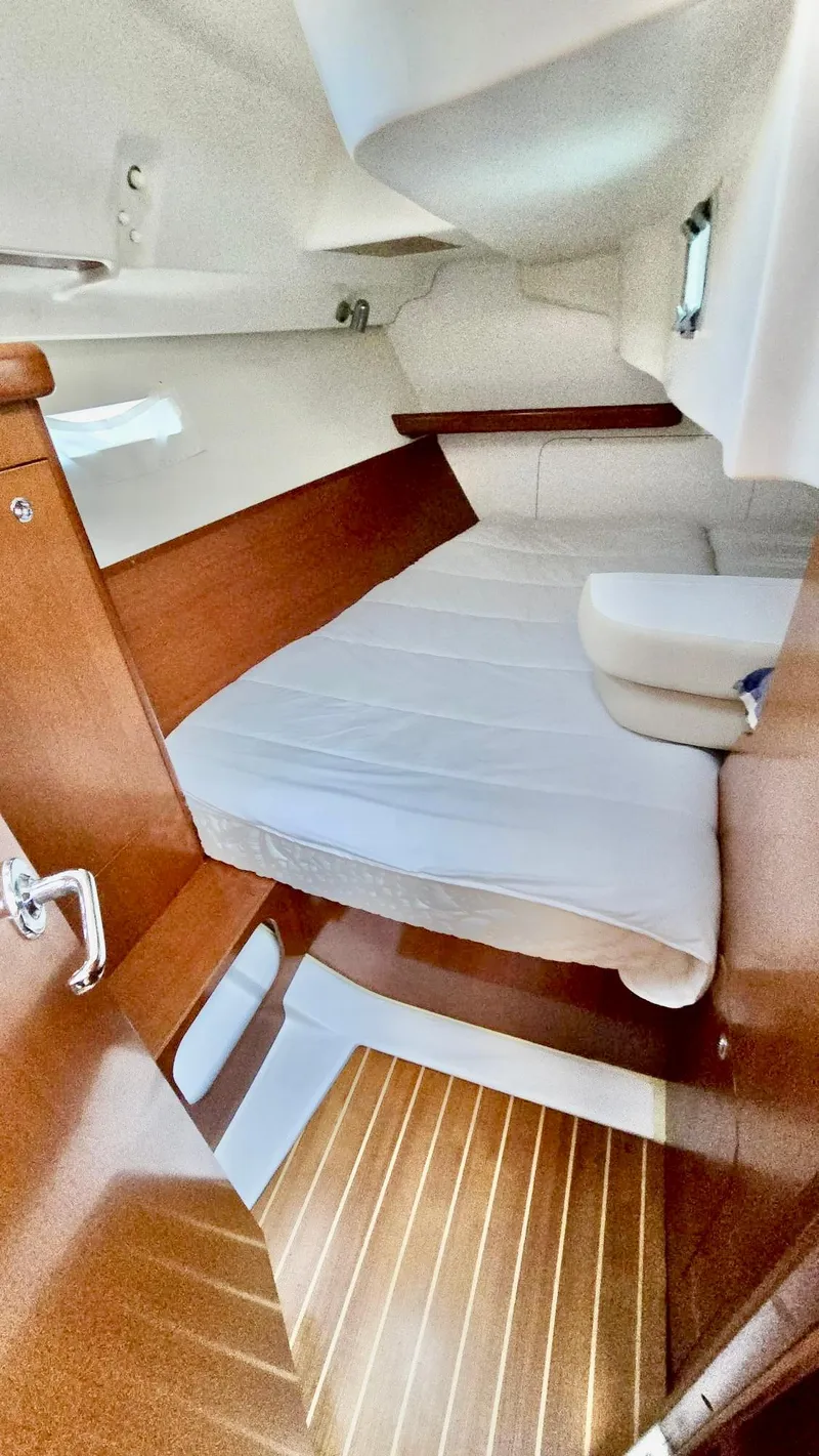 Slide: The Image of 2006 Beneteau 393 cabin interior with wooden finish and comfortable bedding. - 38