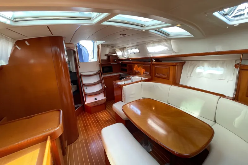 Slide: The Image of Interior of 2006 Beneteau 393 yacht with wood finish and white seating. - 31