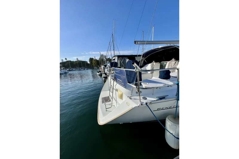 Slide: The Image of A 2006 Beneteau 393 docked in a marina, featuring a clean, white deck. - 24
