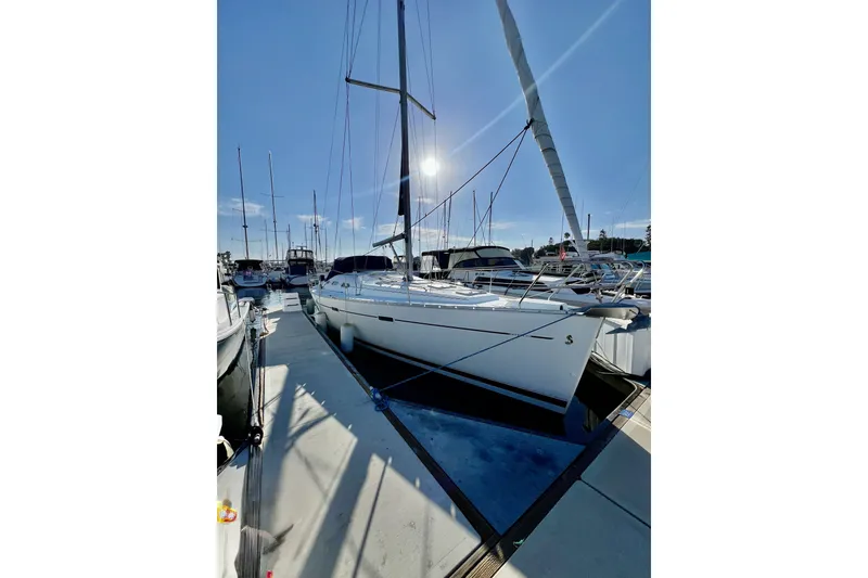 Slide: The Image of A 2006 Beneteau 393 docked at a marina on a sunny day. - 1
