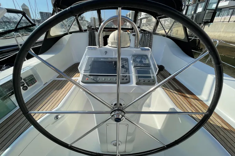 Slide: The Image of Steering wheel and cockpit of a 2006 Beneteau 393 sailboat, featuring navigation instruments. - 16