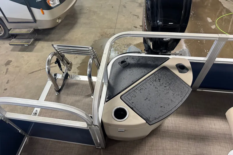 Slide: The Image of 2025 Sun Tracker Bass Buggy 18 DLX pontoon boat interior with motor and ladder. - 16