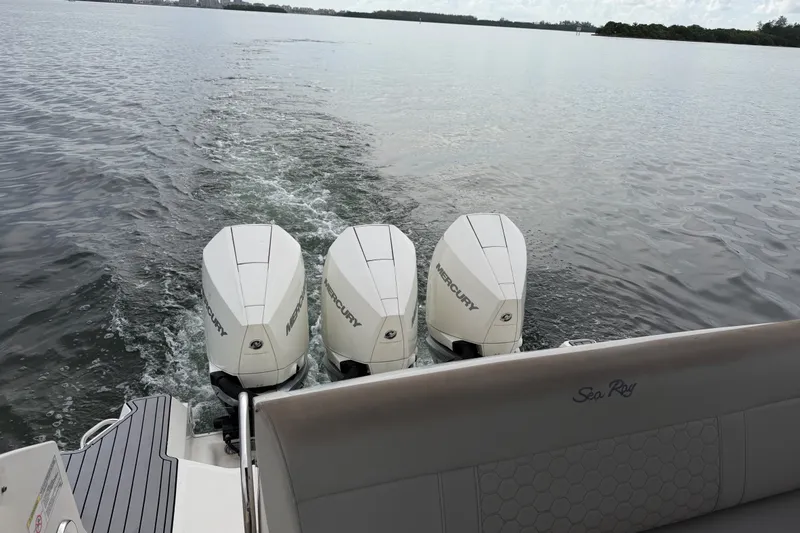 Slide: The Image of 2020 Sea Ray Sundancer 320 Coupe Outboard with triple Mercury engines on calm water. - 48