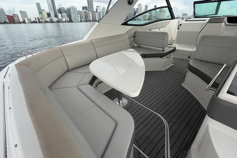 Slide: The Image of 2020 Sea Ray Sundancer 320 Coupe Outboard interior with elegant seating and city skyline view. - 20