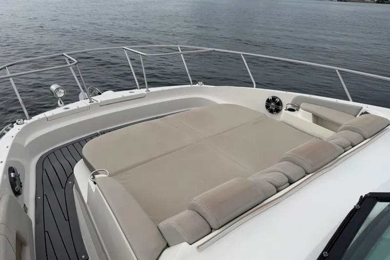 Slide: The Image of 2020 Sea Ray Sundancer 320 Coupe Outboard with spacious sunpad on deck, overlooking calm waters. - 28