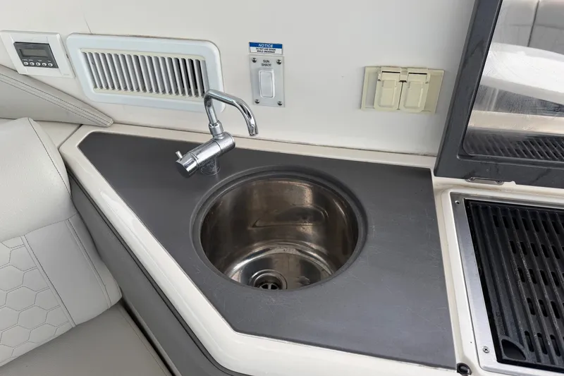 Slide: The Image of 2020 Sea Ray Sundancer 320 Coupe Outboard kitchenette with sink and grill. - 24