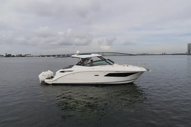 The Image of 2020 Sea Ray Sundancer 320 Coupe Outboard on calm water with bridge in background. - 0