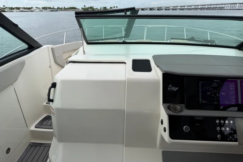 Slide: The Image of 2020 Sea Ray Sundancer 320 Coupe Outboard helm with modern controls and waterfront view. - 10