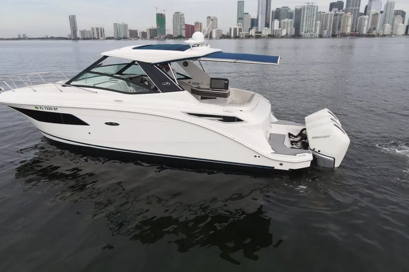 Slide: The Image of 2020 Sea Ray Sundancer 320 Coupe Outboard cruising near city skyline. - 3
