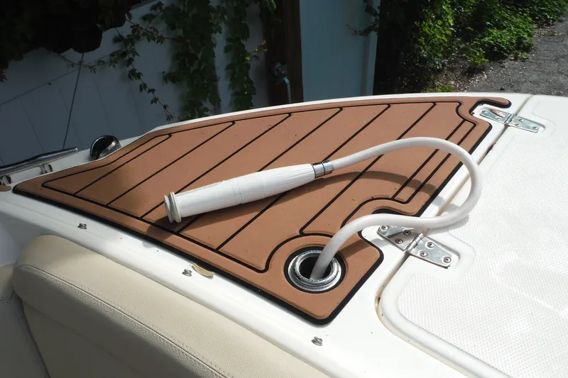 Slide: The Image of Boston Whaler 240 Vantage 2021 boat deck with hose and teak-style flooring. - 33