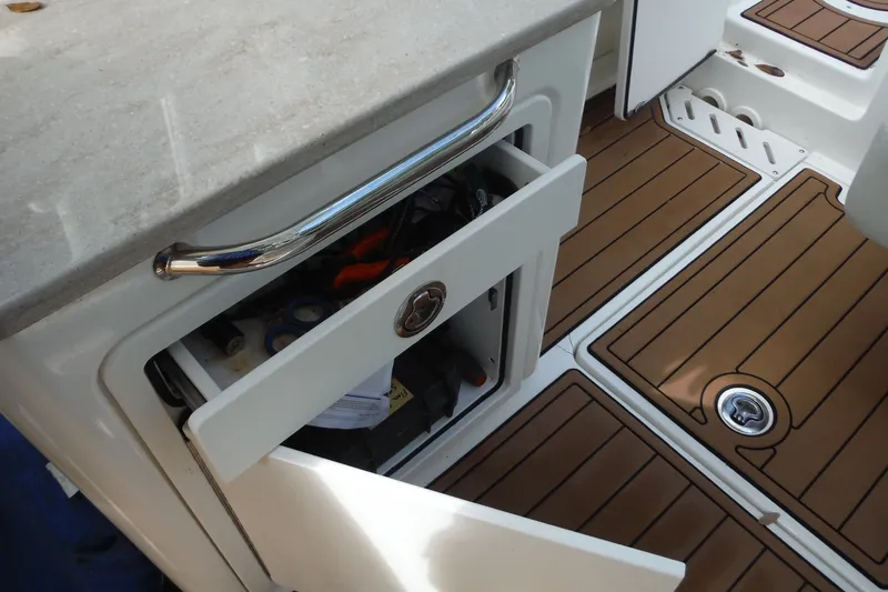 Slide: The Image of Open storage compartment on 2021 Boston Whaler 240 Vantage boat with teak flooring. - 27