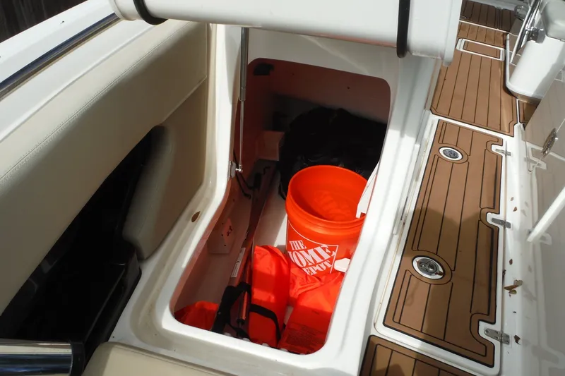 Slide: The Image of Storage compartment on 2021 Boston Whaler 240 Vantage boat with bucket and life jackets. - 39