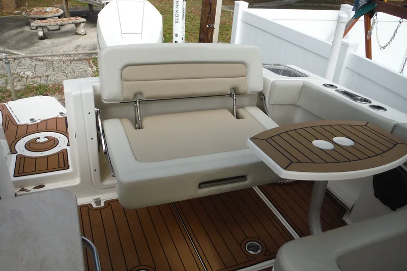 Slide: The Image of 2021 Boston Whaler 240 Vantage boat interior with seating and wooden table. - 17