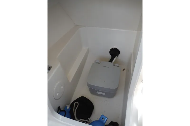 Slide: The Image of Interior storage compartment of 2021 Boston Whaler 240 Vantage boat with portable toilet. - 25