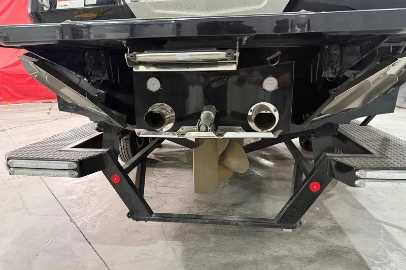 Slide: The Image of Rear view of a 2019 MasterCraft X24 boat on a trailer, showcasing the propeller and exhaust system. - 15