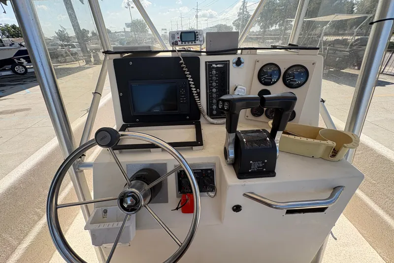 Slide: The Image of 2019 Carolina Skiff 24 DLX boat console with steering wheel and navigation controls. - 19