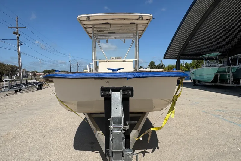Slide: The Image of 2019 Carolina Skiff 24 DLX boat on trailer, parked outdoors under clear sky. - 9