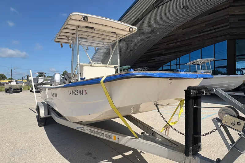 Slide: The Image of 2019 Carolina Skiff 24 DLX boat on trailer, parked outside a modern building. - 10