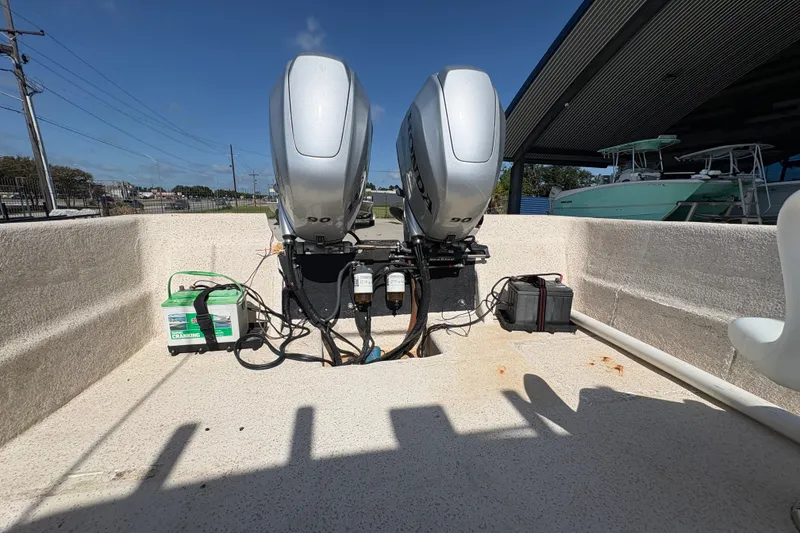 Slide: The Image of 2019 Carolina Skiff 24 DLX boat with dual outboard motors and battery setup. - 14