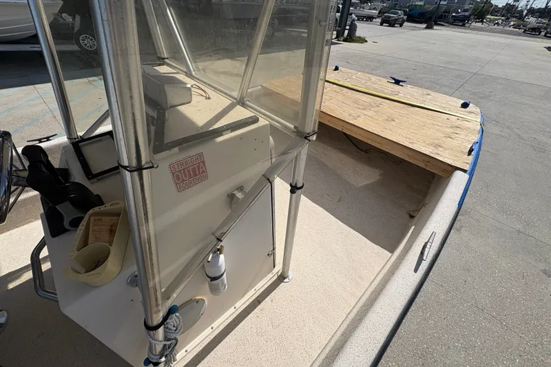 Slide: The Image of 2019 Carolina Skiff 24 DLX boat interior with console and wooden deck. - 16